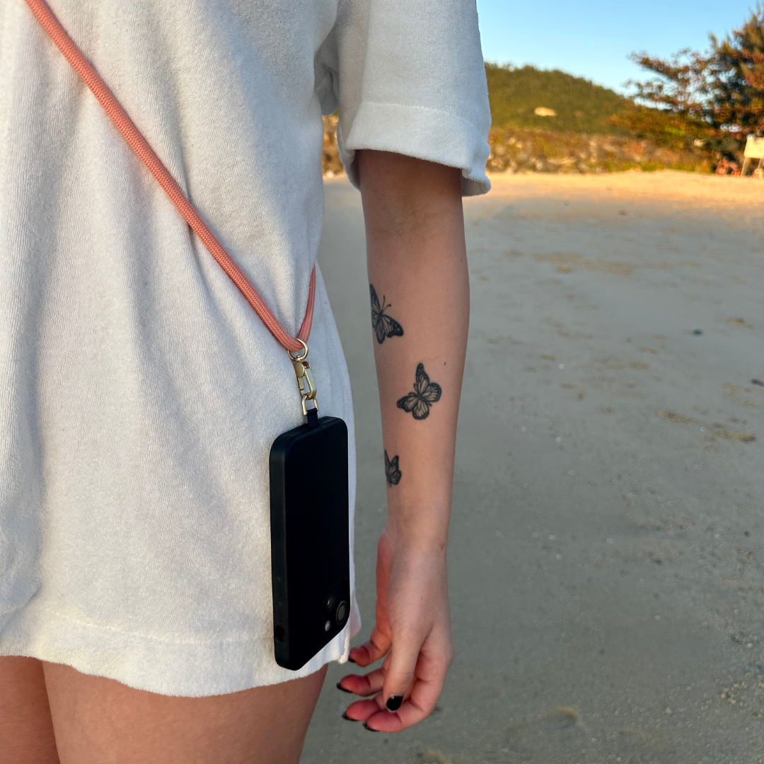 stunning pink crossbody phone strap on a woman with three tattoos