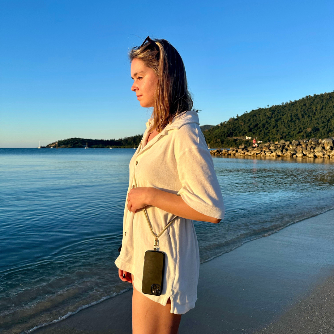 woman wearing a crossbody phone strap at the beach